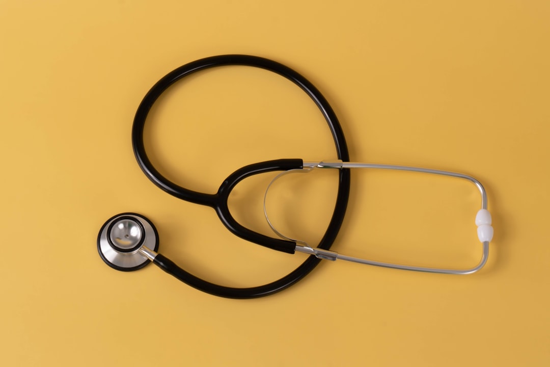 Simple stethoscope on a pastel orange background.